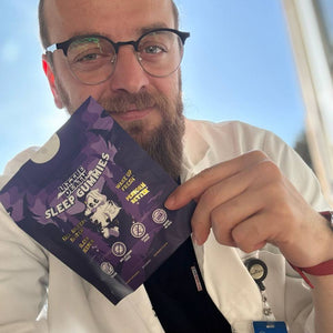 Man holding a purple package labeled 'Sleep Gummies' with a clear background